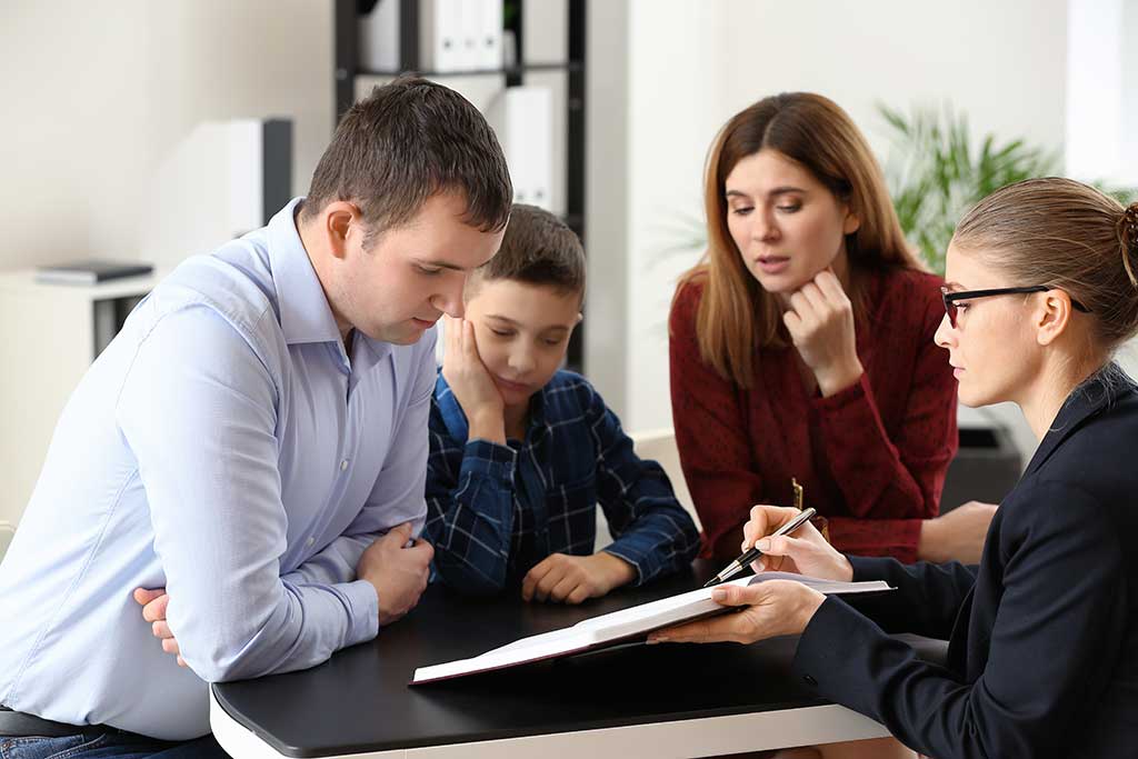 Divorced parents with their son visiting lawyer. Concept of child support